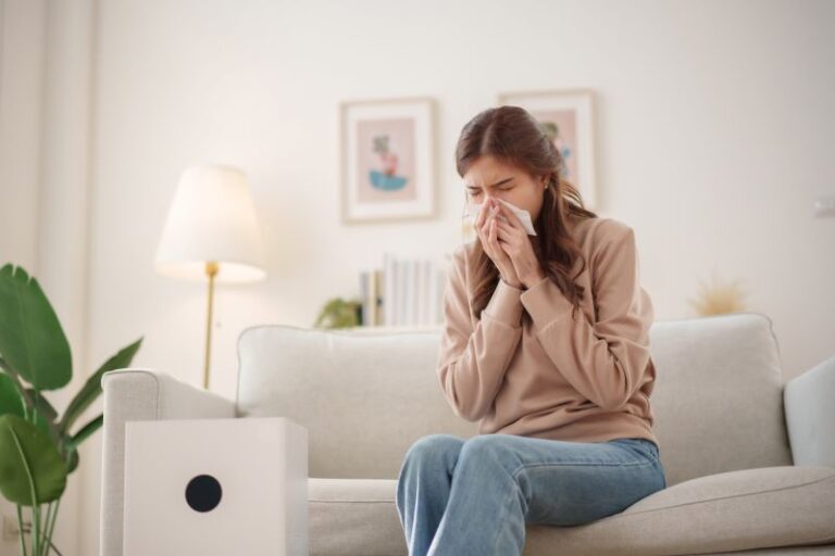 woman sneezing in home - air pollution